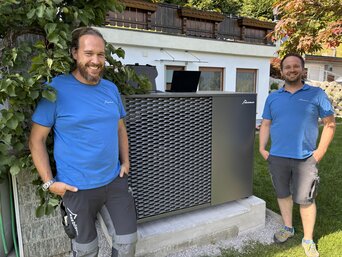 Zwei Mitarbeiter des bösch Kundendienstes stehen neben der installierten MOZART15 Propan Wärmepumpe bei der Inbetriebnahme und Online-Schaltung der Anlage. | © bösch