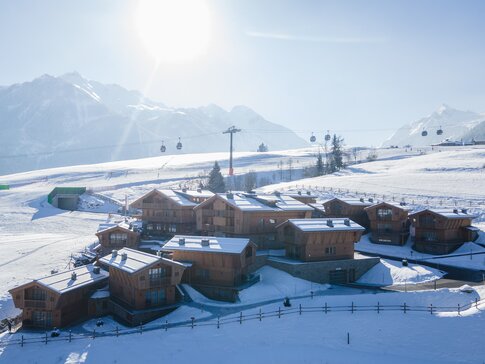 Das Hotel-Dorf Zaglgut zählt zu den TOP 20 der nachhaltigen Hotels in Österreich und besticht mit seinem charmanten Dorfcharakter. | © Hotel & Chalets Zaglgut Hotel-Dorf Zaglgut im Winter mit direkter Lage an der Skipiste und Blick auf die verschneiten Alpen – ausgestattet mit Pelletheizung, Lüftungsanlage und Gebäudeautomation von bösch. | © Hotel & Chalets Zaglgut