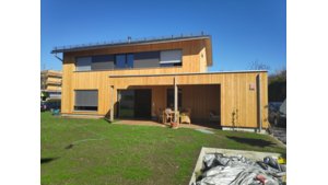 modernes Ziegeldachhaus mit hellem Holz und dunkelgrauen Betonwände innen | © bösch heizung.klima.lüftung