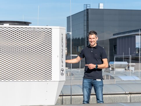 Moderne Klimatechnik bei ENGEL Austria Mitarbeiter präsentiert die INFRANORM®-Kühleinheit des Sustainable Hall Conditioning Systems von bösch und INFRANORM® am Standort ENGEL Austria in Schwertberg