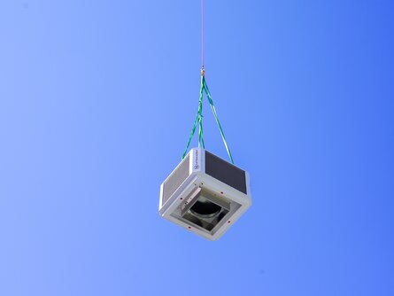 Helikopter-Transport für SHC-Installation bei ENGEL Helikopter hebt Anlagenteile zur ENGEL-Produktionshalle für die Installation des Sustainable Hall Conditioning Systems von bösch und INFRANORM®
